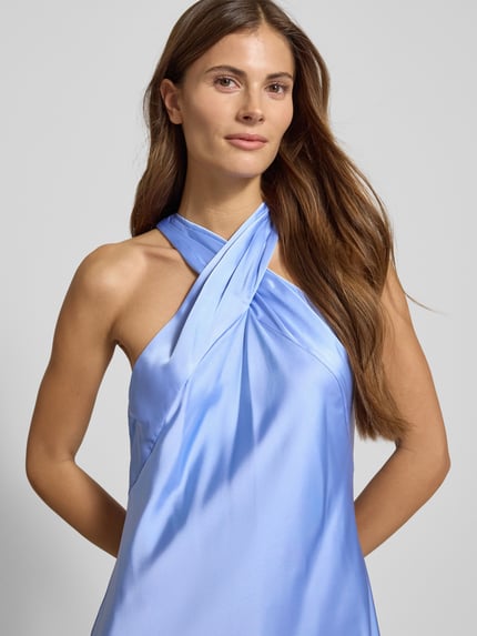 Vrouwenmodel draagt knielanges Cocktailkleid mit Neckholder van Lauren Ralph Lauren in lichtblauw, taillering, mix van materialen, Nahaufnahme bovenlichaam.