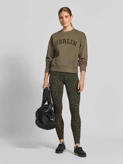 Frauenmodel trägt Leggings aus Viskose-Mix von Lala Berlin mit Leopardenmuster, High Waist und elastischem Bund, Ganzkörperansicht von vorne.