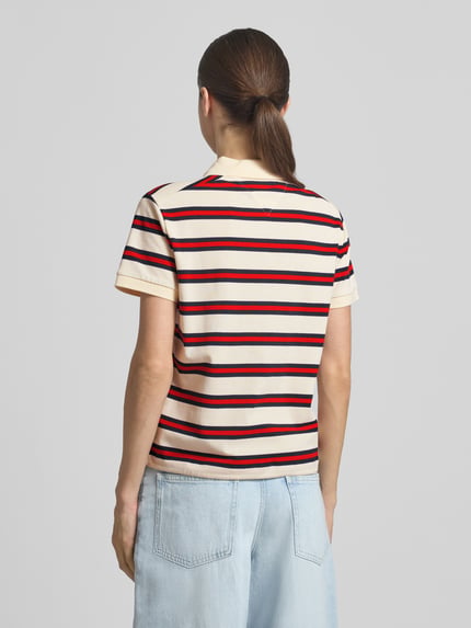 Frauenmodel trägt Regular Fit Poloshirt aus Baumwoll-Mix von Tommy Hilfiger, gestreift, kurzarm, Logo-Detail, Ganzkörperansicht Rückansicht.