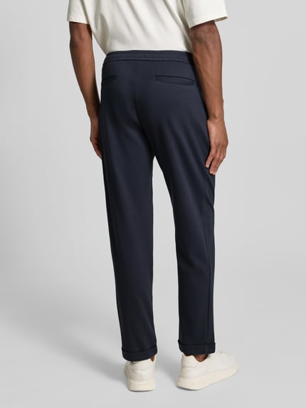 Mannelijk model draagt Stoffhose met Gesäßtaschen van MCNEAL in donkerblauw, rechte snit, detailopname achterkant.
