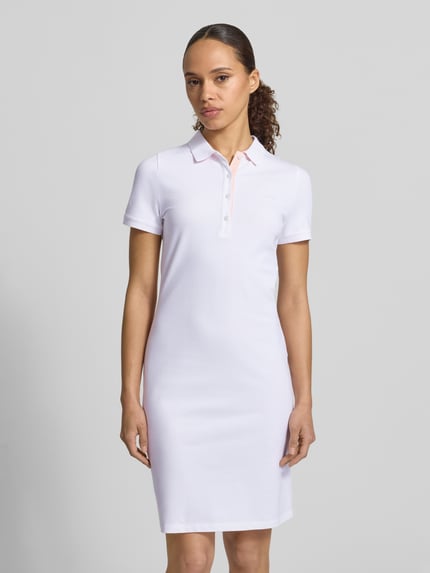 Frauenmodel trägt Knielanges Polokleid mit Label-Stitching von Gant in Weiß, Baumwoll-Elasthan-Mix, gerader Schnitt, Ganzkörperansicht von vorne.