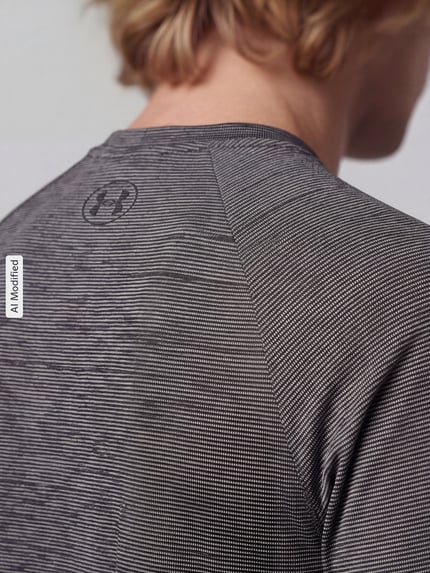 Männermodel trägt Regular Fit Sport-T-Shirt mit Logo-Print von Under Armour, feine graue Struktur, Nahaufnahme Oberkörper, KI-modifiziertes Bild.