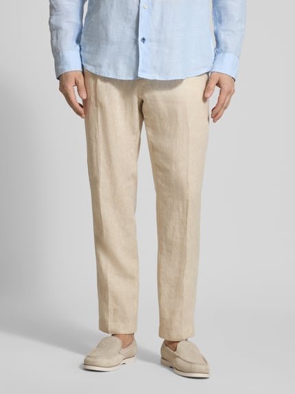 Männermodel trägt Hose mit Bügelfalten und Tunnelzug von Manuel Ritz aus reiner Baumwolle in Beige, Regular Fit, Ganzkörperansicht von vorne.