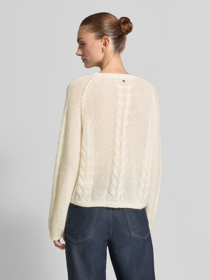 Frauenmodel trägt Regular Fit Pullover aus reiner Baumwolle Modell 'C_Fypera' von BOSS Orange in Creme, leichte Stricktextur, Ganzkörperansicht Rückansicht.