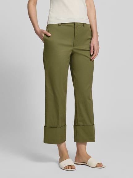 Kobiece model prezentuje spodnie z mieszanki bawełny z dodatkiem streczu od Stefanel, model 'PANTALONE', krój straight fit, oliwkowy kolor, wpuszczane kieszenie, zapięcie na haftkę i zamek błyskawiczny, zakładka na dole, widok całej sylwetki z przodu, szerokość w rozmiarze 36: 35 cm, długość wewnętrzna nogawki 66 cm.
