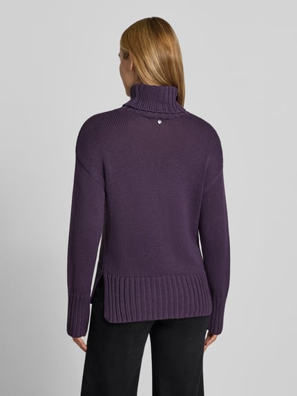Frauenmodel trägt Relaxed Fit Strickpullover aus reiner Baumwolle mit Rollkragen von MOS MOSH in Dunkellila, elastische Abschlüsse, Ganzkörperansicht Rückansicht.