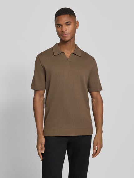 Męski model nosi Strickshirt mit V-Ausschnitt Modell 'MILANO' von Jack & Jones Premium z mieszanki bawełny, prosty krój, wykładany kołnierz, dekolt w serek, detal z logo, długość tyłu w rozmiarze M: 69 cm, widok całej sylwetki z przodu