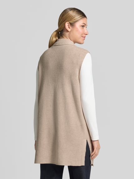 Frauenmodel trägt Strickweste aus Viskose-Mix mit offener Front von Christian Berg Woman, beige, Feinripp, Straight Fit, Rückenlänge S 77 cm, Ganzkörperansicht Rückansicht.