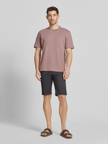 Männermodel trägt Slim Fit Chinoshorts aus Baumwoll-Mix von Tom Tailor, Optik:Allover-Muster, feines Webmuster, Twill, Ganzkörperansicht von vorne.