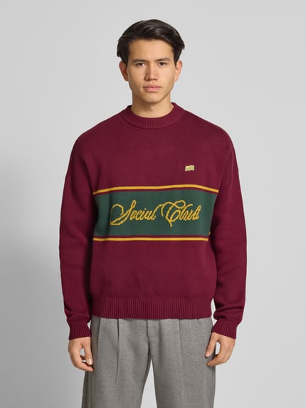 Männermodel trägt Strickpullover mit Rundhalsausschnitt von PROHIBITED, Reine Baumwolle, Relaxed-Fit, Kontraststreifen, Ganzkörperansicht von vorne.