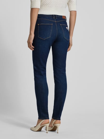 Vrouwenmodel draagt Jeans met 5-Pocket-Design van Guess in donkerblauw, slim fit, katoenmix, rechte vorm, detailopname rugaanzicht.