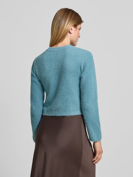Frauenmodel trägt Strickjacke mit Pattentaschen von Betty Barclay in Uni-Blau, Strukturstrick, Regular Fit, Ganzkörperansicht Rückansicht.
