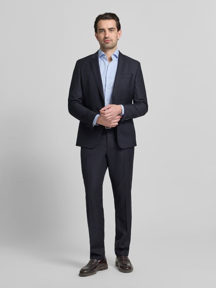 Männermodel trägt Slim Fit Businesshemd aus reiner katoen Modell 'HANK' van BOSS met gestreept patroon, haifischkraag, lange mouwen, afgeronde zoom, eenrijige knoopsluiting, label stitching, sportmanchet, rugpas, ganzlichaamsvooraanzicht.
