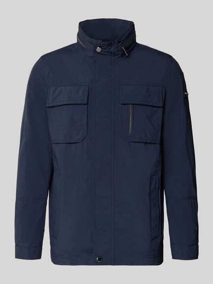 Produktfoto, Regular Fit Jacke mit Stehkragen von bugatti in Dunkelblau mit Brusttaschen, verstaubarer Kapuze und Logo-Applikation. Rückenlänge 72 cm, Schulterbreite 46 cm, Brustweite 52 cm, Ärmellänge 68 cm in Größe 50.
