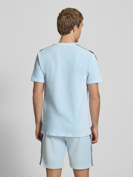Männermodel trägt Herren T-Shirt mit Logo Modell 'MADORI' von Ellesse aus hellblauem Baumwoll-Mix mit Stretch-Anteil, Regular-Fit, Rückansicht.