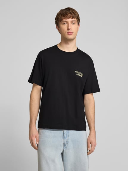 Männermodel trägt Herren T-Shirt mit Statement-Print Modell 'NORREBRO' von Jack & Jones in Schwarz aus Reine Baumwolle, gerader Schnitt, Rundhalsausschnitt, Ganzkörperansicht von vorne.
