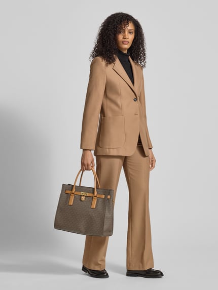 Frauenmodel trägt Satchel Bag mit Tragehenkel Modell 'HAMILTON' von MICHAEL Michael Kors mit Label-Detail, Reißverschluss, Schulterriemen, Hauptfach; Ganzkörperansicht von vorne.