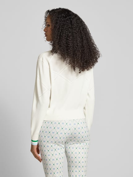 Frauenmodel trägt Strickjacke aus Viskose-Mix mit Zweiwege-Reißverschluss von Marc Cain in Weiß, Regular-Fit, V-Ausschnitt, Rückenlänge 55 cm, Ärmellänge 61 cm, Ganzkörperansicht Rückansicht.