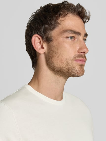Männermodel trägt Regular Fit T-shirt uit puur katoen Model 'TORINO' van SELECTED HOMME in effen look, ronde hals, korte mouw, detailopname zijaanzicht.