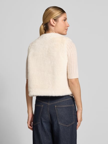 Frauenmodel trägt Weste aus Kunstfell mit Knopfverschluss von Milano Italy in Creme, Regular Fit, Rückenansicht, Kontext: Damen Weste, Kunstfell, Rundhalsausschnitt, Rückenlänge 49 cm, Schulterbreite 37 cm, Brustweite 51 cm.