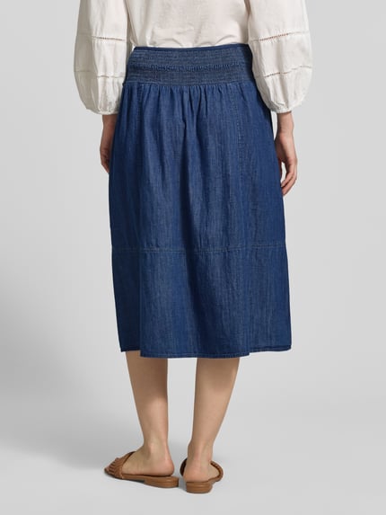 Vrouwenmodel draagt jeansrok met elastische band, puur katoen, a-lijn, midirok, model 'Ropini' van OPUS, geheel achteraanzicht