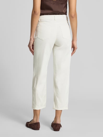 Frauenmodel trägt Straight Fit Hose in verkürzter Passform Modell 'Melly' von OPUS PANTS, cremige Farbe, Baumwoll-Mix, 5-Pocket-Design, Knopf-Reißverschluss, Ganzkörperansicht Rückansicht.