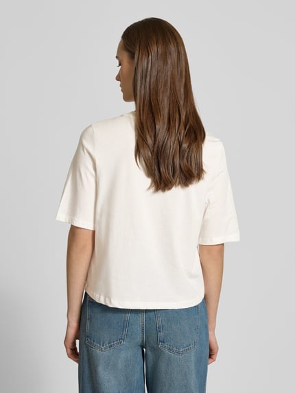 Frauenmodel trägt Damski t-shirt Relaxed Fit T-Shirt aus reiner Baumwolle Modell 'CARTY' von ONLY, efekt: jednolity kolor, nadruk z motywem, okrągły dekolt, krótki rękaw, dżersej, czysta bawełna, całkowity widok od tyłu