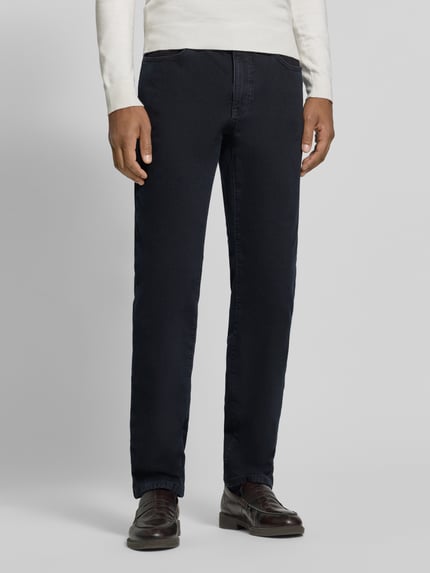 Männermodel trägt Straight Fit Jeans Modell 'Cadiz' von Brax aus dunkelblauem Baumwoll-Mix mit 5-Pocket-Design, Ganzkörperansicht von vorne.