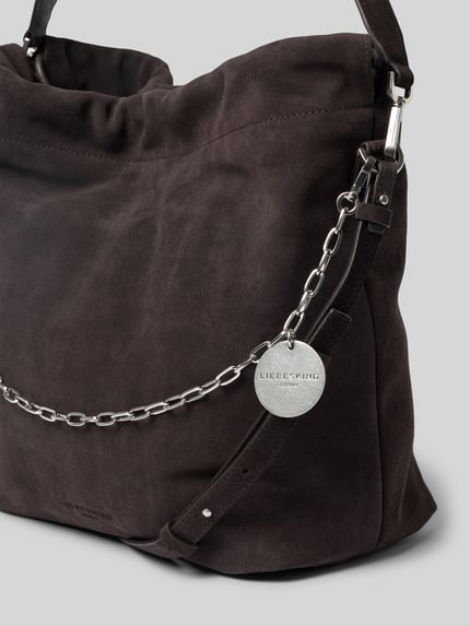 Productfoto, Handtasche aus echtem Veloursleder Modell 'Lya' van LIEBESKIND BERLIN in donkerbruin suède met reliëflogo, hoofdvak met tunnelkoord, afneembare schouderband, breedte 44 cm, lengte 36 cm, diepte 16 cm, bandlengte 120 cm, zilverkleurige metalen ketting, gladde textuur