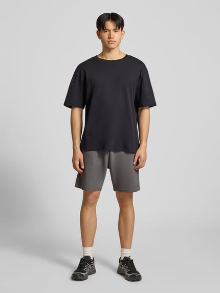 Männermodel trägt Shorts mit Strukturmuster von REVIEW aus Baumwoll-Mix, Regular-Fit, elastischer Bund, Ganzkörperansicht von vorne.