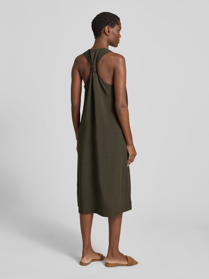 Frauenmodel trägt Relaxed Fit Midikleid aus Viskose-Mix Modell 'Waka' von OPUS in Olivgrün mit Eingrifftaschen und Ärmelloses-Design, Leinen-Viskose-Anteil, Ganzkörperansicht Rückansicht.