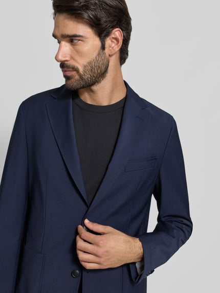 Męski model nosi Regular Fit Anzugsakko aus Schurwoll-Mix Modell 'HANRY' von BOSS, efekt: jednolity kolor, kołnierz z połami, jednorzędowy, zapięcie na 2 guziki, Brustasza, kieszenie z patką, oddychający materiał; mieszanka żywej wełny, Nahaufnahme górnej części ciała.