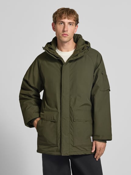 Männermodel trägt olivgrünen Parka mit Pattentaschen Modell 'Stanwood' von Carhartt Work In Progress, Regular Fit, Ganzkörperansicht von vorne.