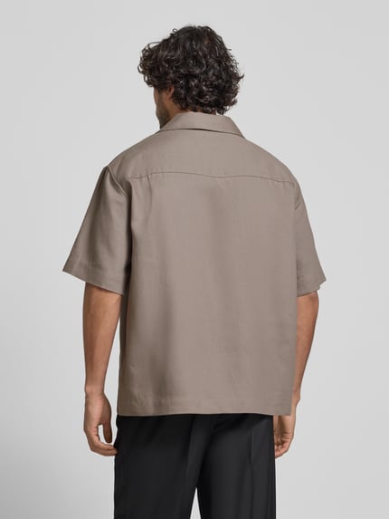 Männermodel trägt Relaxed Fit Freizeithemd aus Hanf-Lyocell-Mix Modell 'ESPINO' von HUGO in Beige, Twillstruktur, Ganzkörperansicht Rückansicht.