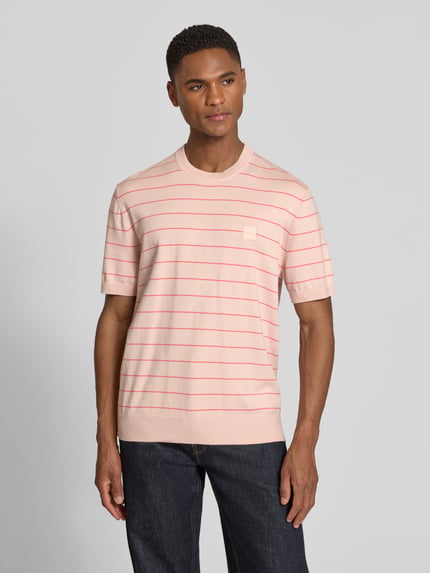 Männermodel trägt Regular Fit T-Shirt aus Baumwoll-Kaschmir-Mix Modell 'KANACHO' von BOSS Orange, fein gestrickt, gestreift, Frontansicht.