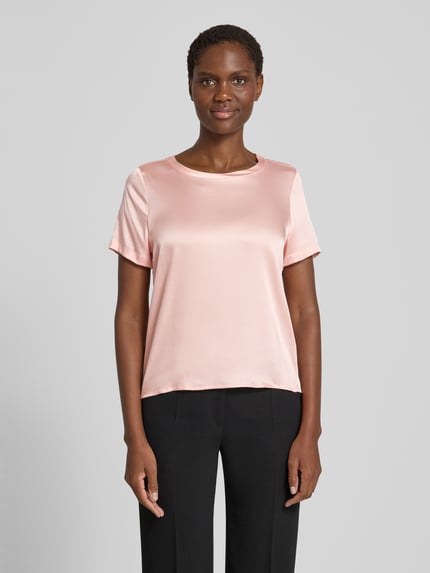 Frauenmodel trägt Blusenshirt aus Satin mit Rundhalsausschnitt von Christian Berg Woman Selection in zartem Rosé, glatte Oberfläche, Ganzkörperansicht von vorne.