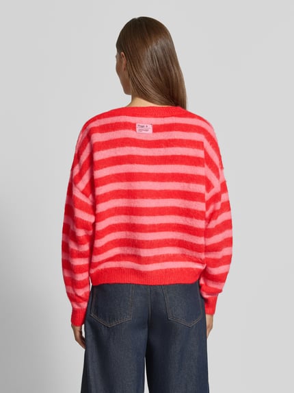 Vrouwenmodel draagt gebreid jack in rood en roze strepen, Materiaalmix met wol, regular fit, Knoopsluiting, Model 'BLUSH' van ICHI, all-over look, v-hals, ruglengte maat S 51 cm, mouwlengte maat S 65 cm, Ganzkörperansicht Rückansicht.