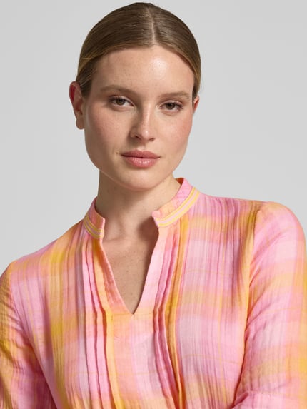 Vrouwenmodel draagt Relaxed Fit Midikleid met Tunika-Kragen van Emily Van den Bergh in katoenmix met plooien, roze en oranje, nahaufnahme bovenlichaam.