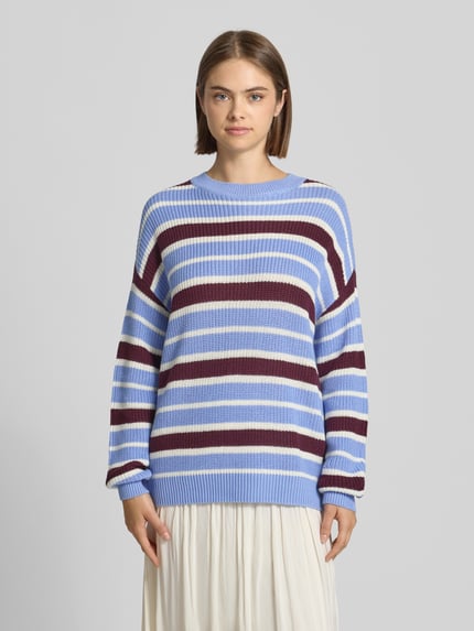 Modelka nosi Relaxed Fit Pullover aus Baumwoll-Mix Modell 'Maysa' von NOISY MAY®, dzianinowy wzór, pastelowe niebieskie i bordowe pasy, długość tyłu w rozmiarze S: 67 cm, długość rękawa w rozmiarze S: 58 cm, widok całej sylwetki z przodu.
