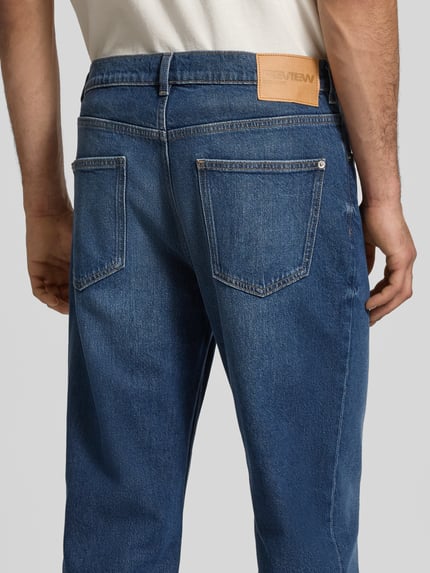 Männermodel trägt Straight Fit Jeans im 5-Pocket-Design von REVIEW, blauer Baumwoll-Mix, Detailaufnahme Rückansicht, Bundweite 45 cm, Innenbeinlänge 78 cm.