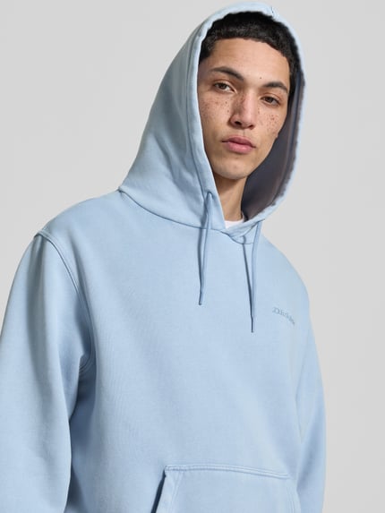 Męski model nosi Hoodie mit Label-Stitching und Känguru-Tasche od Dickies, bawełniany miks, krój relaxed fit, niebieski, zbliżenie na górę ciała