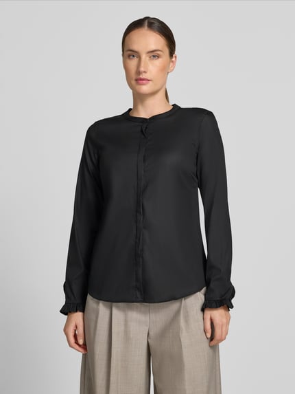 Frauenmodel trägt Bluse mit Mao-Kragen und Rüschenärmeln Modell 'Mattie' von MOS MOSH, schwarze Farbe, Straight Fit, Nahaufnahme Oberkörper. Baumwoll-Mix mit Stretch-Anteil, verdeckte Knopfleiste, KI-modifiziertes Bild.