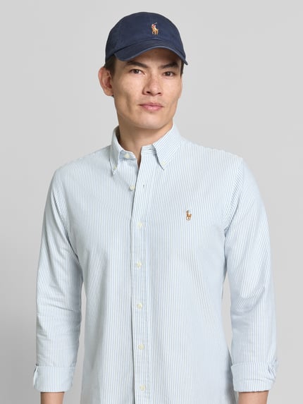 Männermodel trägt Regular Fit Freizeithemd aus reiner Baumwolle von Polo Ralph Lauren, hellblau-weiß gestreift, Logo-Stitching, Nahaufnahme Oberkörper.