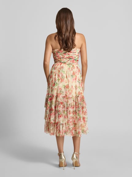 Frauenmodel trägt Midikleid mit floralem Allover-Print von LACE & BEADS, Tailliert, Gelegte Falten, Rüschenbesatz, Schulterfrei, Rückenlänge 110 cm, Brustweite 35 cm, sanfte Pastellfarben, Ganzkörperansicht Rückansicht.
