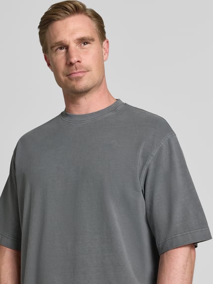 Männermodel trägt Boxy Fit T-Shirt aus reiner Baumwolle Modell 'CORY' von Selected Homme in Grau, Herren T-Shirt, Nahaufnahme Oberkörper.