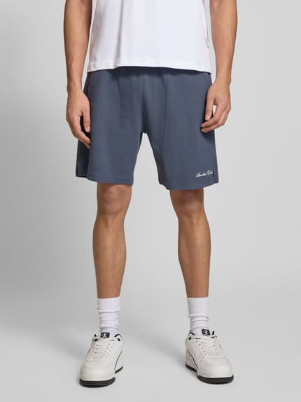 Männermodel trägt Shorts mit Logo-Print und Eingrifftaschen von ANOTHER COTTON LAB, Baumwoll-Mix, Lockerer-Schnitt, Nahaufnahme Oberkörper.