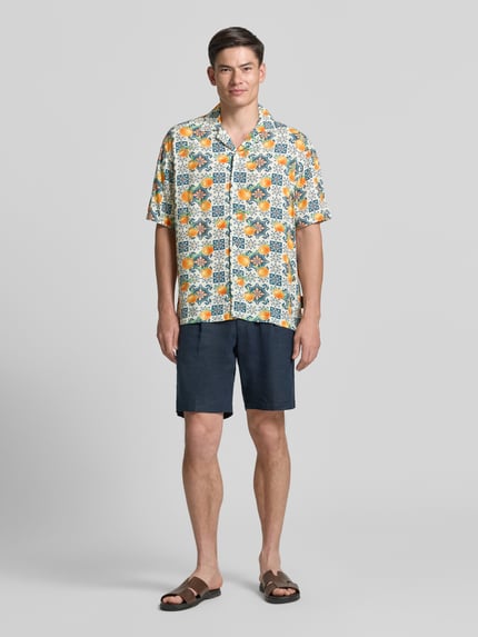 Männermodel trägt Loose Fit Freizeithemd aus reiner Viskose von Tom Tailor Denim mit Allover-Muster, Two Tone, Reverskragen, kurze Ärmel, Knopfleiste, Ganzkörperansicht von vorne.