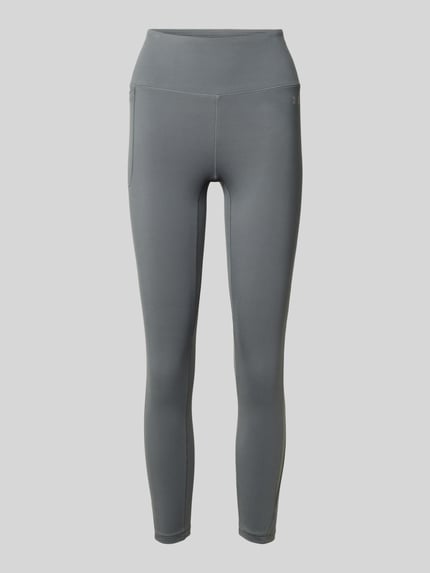 Produktfoto, Slim Fit Leggins mit semitransparenten Partien Modell 'Motion' von Under Armour, elastyczna mieszanka materiałów, krój slim fit, półprzezroczyste elementy, kieszeń na nogawce, szeroki pas, nadruk z logo, skrócony krój, kolor szary