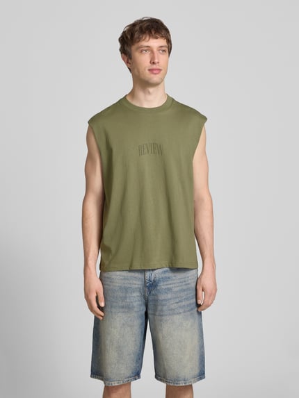 Männermodel trägt Muskelshirt mit Logo und Rundhalsausschnitt von REVIEW, grün, Reine Baumwolle, Regular-Fit, Logo, Ganzkörperansicht von vorne. Rückenlänge bei Größe M: 68 cm.