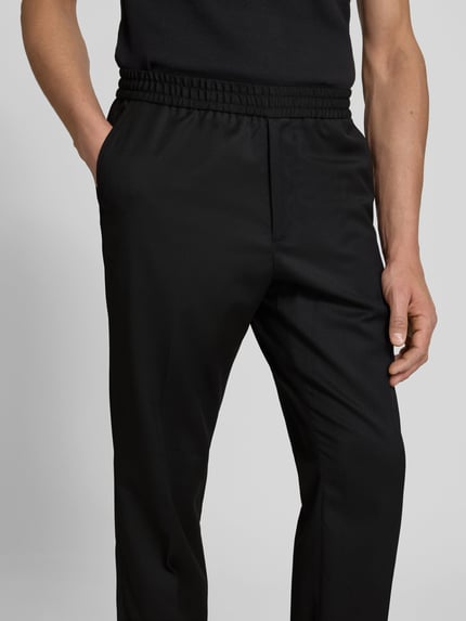 Männermodel trägt Straight Fit Stoffhose mit Woll-Anteil von Filippa K in Schwarz, elastischer Bund, Bundfalten, Nahaufnahme Oberkörper